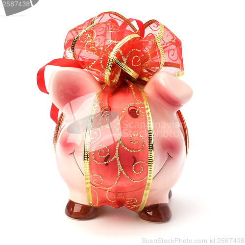 Image of Christmas deposit concept. Piggy bank with festive bow isolated 