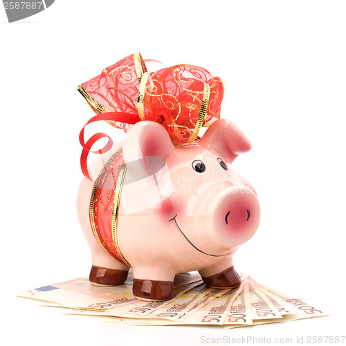 Image of Christmas deposit concept. Piggy bank with festive bow isolated 
