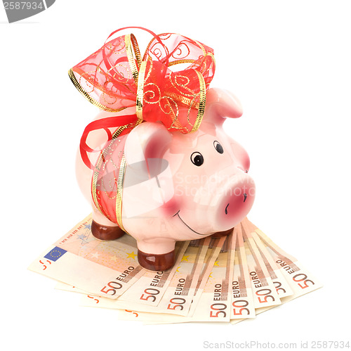 Image of Christmas deposit concept. Piggy bank with festive bow isolated 