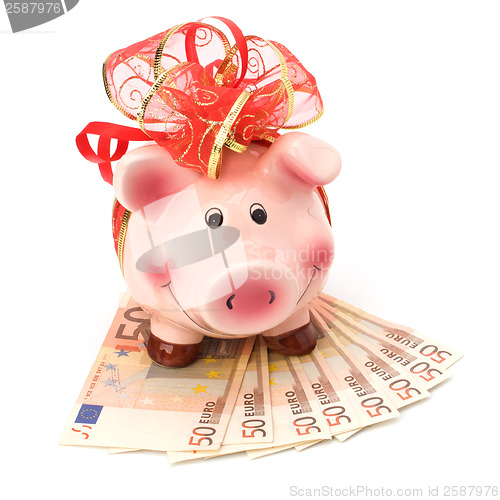 Image of Christmas deposit concept. Piggy bank with festive bow isolated 