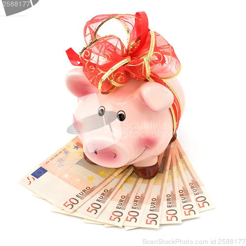 Image of Christmas deposit concept. Piggy bank with festive bow isolated 