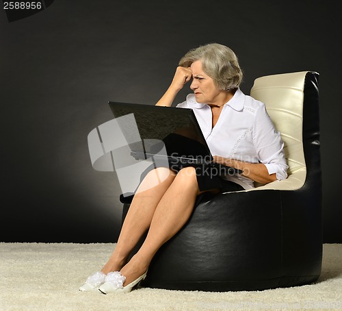 Image of Happy beautiful senior woman with laptop