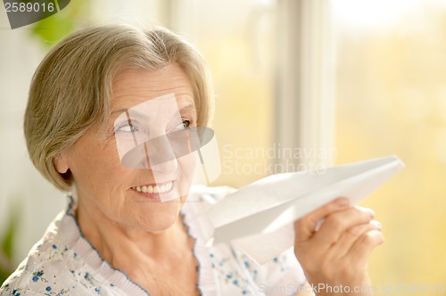 Image of Senior woman with paper plane