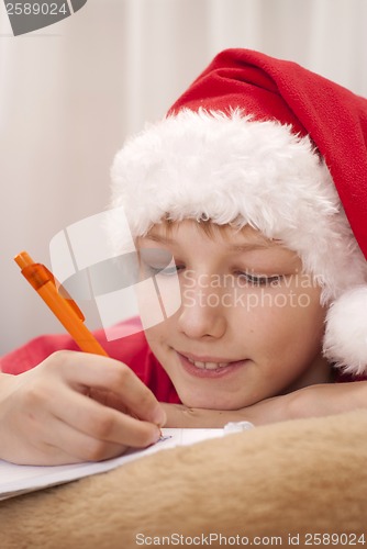 Image of Boy in santa hat writing