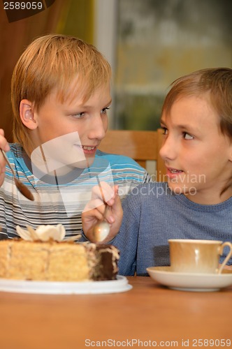 Image of Two little brothers eat cake