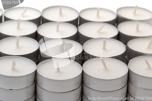 Image of Rows of white wax tea light candles