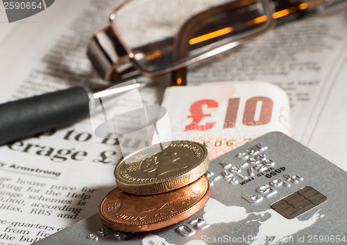 Image of Glasses, coins, credit cards and banknotes on newspaper