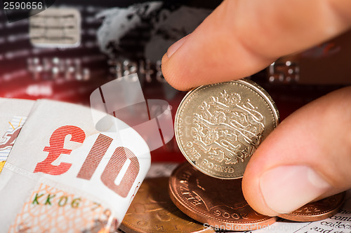 Image of Coins, credit cards and british pounds on newspaper