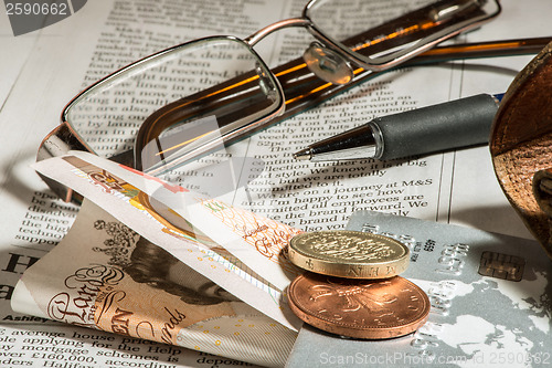 Image of Glasses, coins, credit cards and banknotes on newspaper