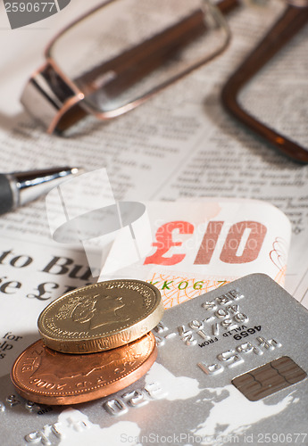 Image of Glasses, coins, credit cards and banknotes on newspaper