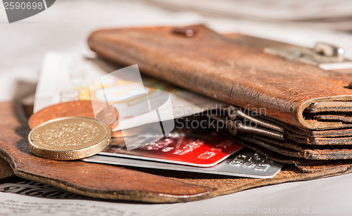 Image of Coins, credit cards and british pounds on newspaper