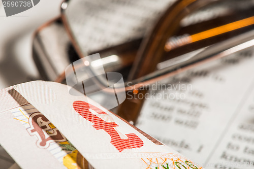 Image of Glasses, coins, credit cards and banknotes on newspaper