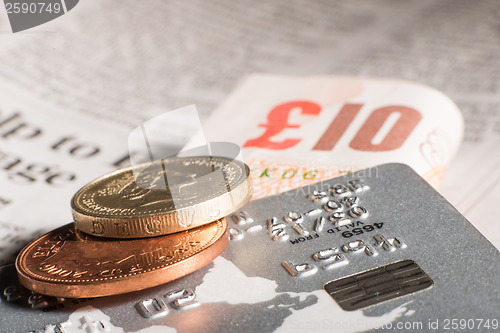 Image of Coins, credit cards and banknotes on newspaper.