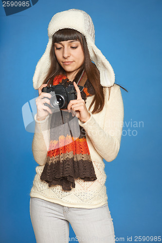 Image of Woman photographer adjusting photo camera settings