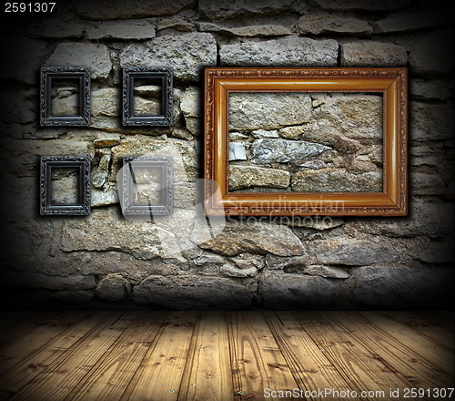 Image of stone wall with wood painting frames