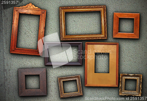 Image of lots of picture frames hung on green wall