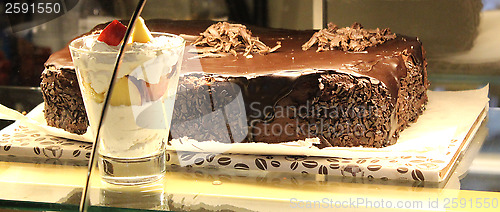 Image of chocolate cake and ice-cream in the shopwindow