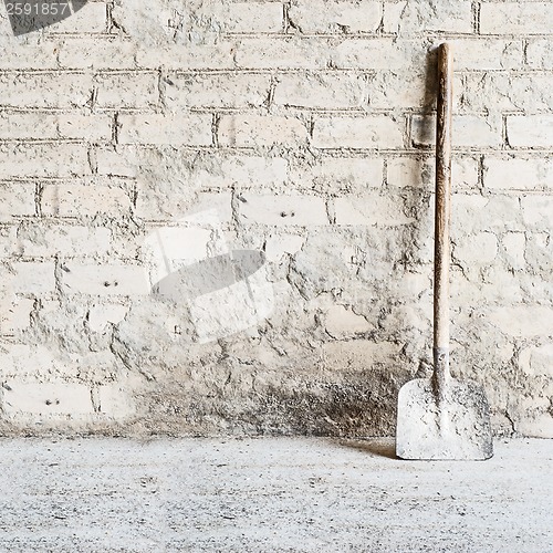 Image of grunge wall background at the mill, shovel near the wall