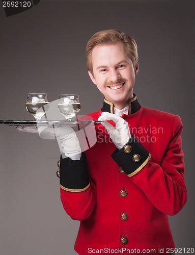 Image of Smiling Waiter in red uniform