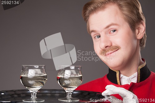 Image of Smiling Waiter in red uniform