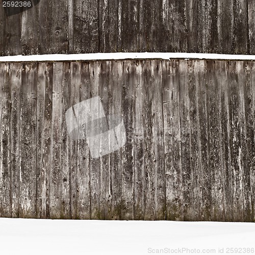 Image of plank wooden wall in winter, snow on the ground