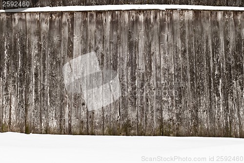 Image of plank wooden wall in winter, snow on the ground