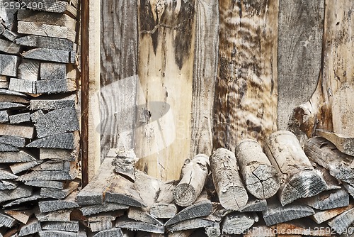 Image of fire wood pile near the plank wall