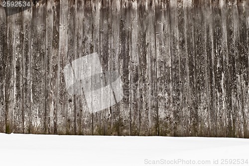 Image of plank wooden wall in winter, snow on the ground