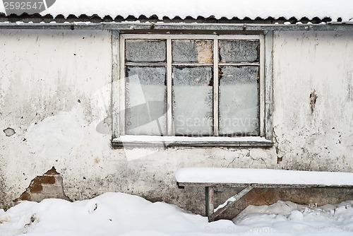 Image of wall with window background, bench near the wall, slate roof and