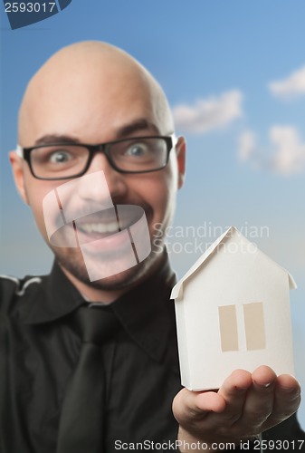 Image of Man holding a paper house.