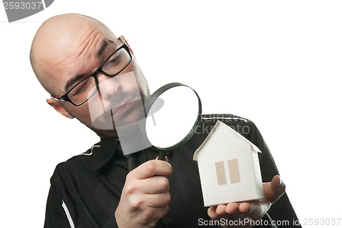 Image of Man with a magnifying glass and paper house