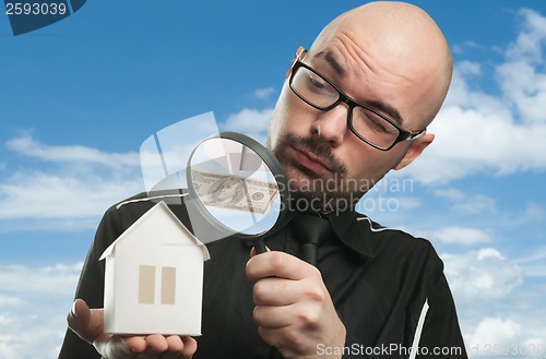 Image of Man with a magnifying glass and paper house