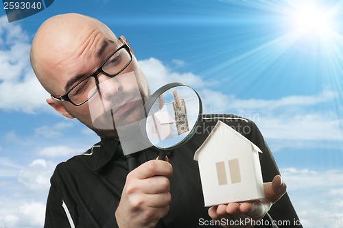 Image of Man with a magnifying glass and paper house