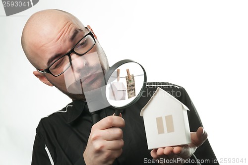 Image of Man with a magnifying glass and paper house