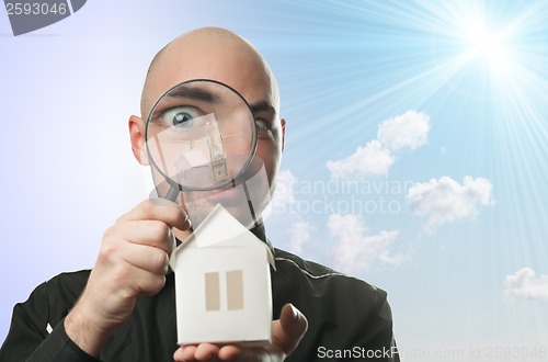 Image of Man with a magnifying glass and paper house