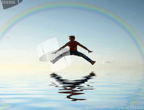 Image of jump over water under rainbow