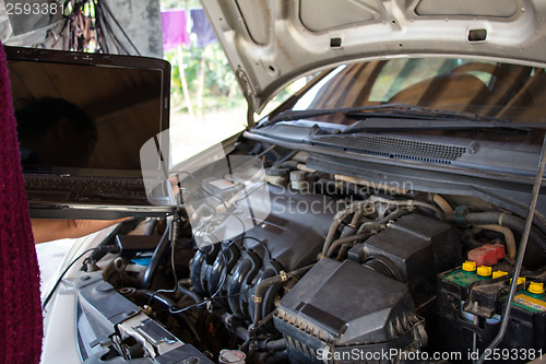 Image of Car mechanic checking engine