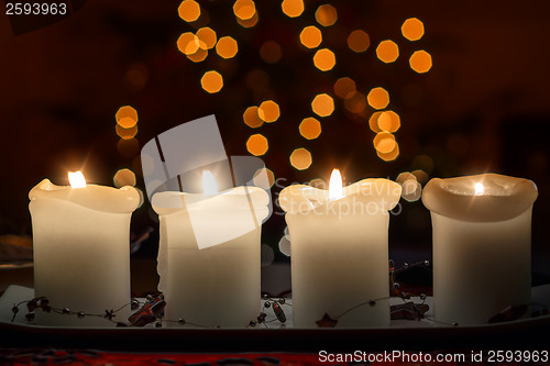 Image of Burning candle with christmas tree bokeh