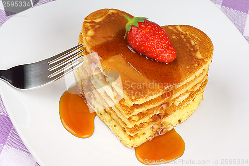Image of Heart-shaped pancakes with syrup and strawberry