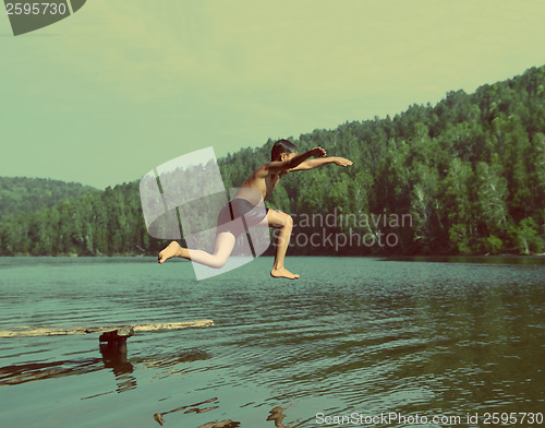 Image of boy jumping in lake - vintage retro style