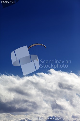 Image of Silhouette of paraglider and blue sky with clouds