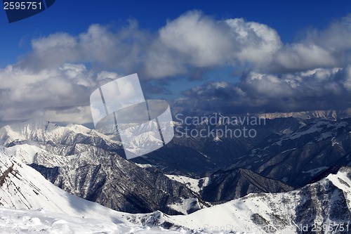 Image of Sunlit winter mountains in clouds, view from off-piste slope