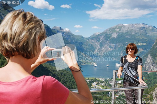 Image of Tourists taking photo against Geirangerfjord