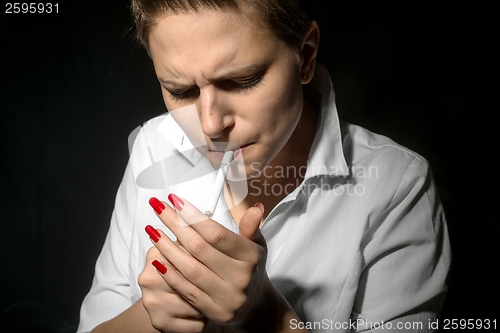Image of Young woman smoking in the studio