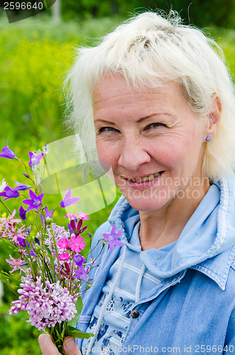 Image of Portrait of a middle-aged woman with a bouquet of wild flowers