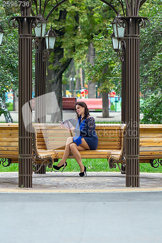Image of Girl reading book in the park