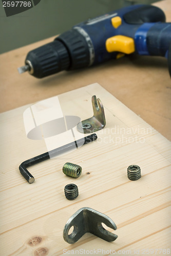 Image of Furniture parts and electric screwdriver on table