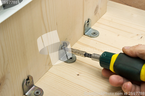 Image of Screwing a screw at manufacturing of wooden furniture