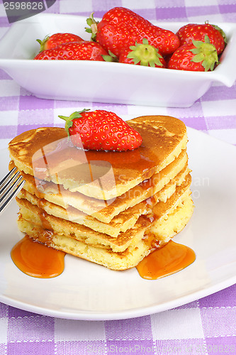Image of Stack of heart-shaped pancakes with syrup and strawberry