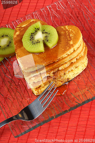 Image of Stack of heart-shaped pancakes with syrup and kiwi fruit